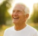 Un senior plus, en t-shirt blanc, heureux et en bonne santé qui rayonne de bonheur représente bien le blog papy-max.fr